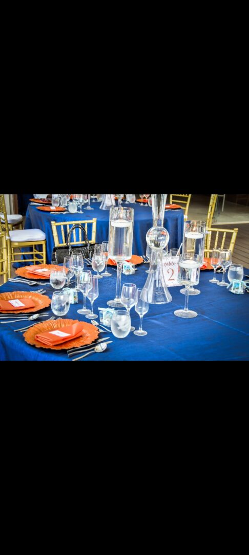 A table set with orange plates and glasses.