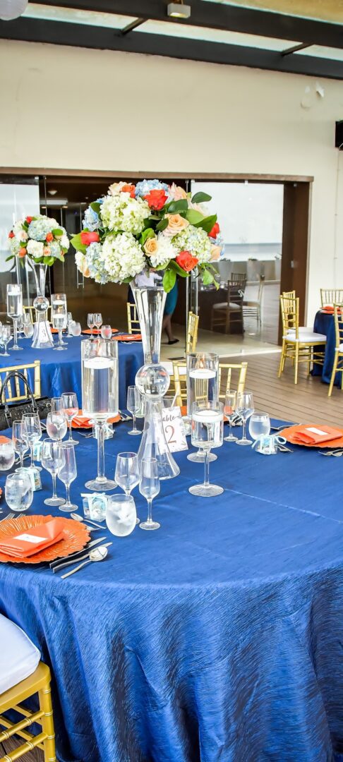 A table set up with blue linens and orange plates.