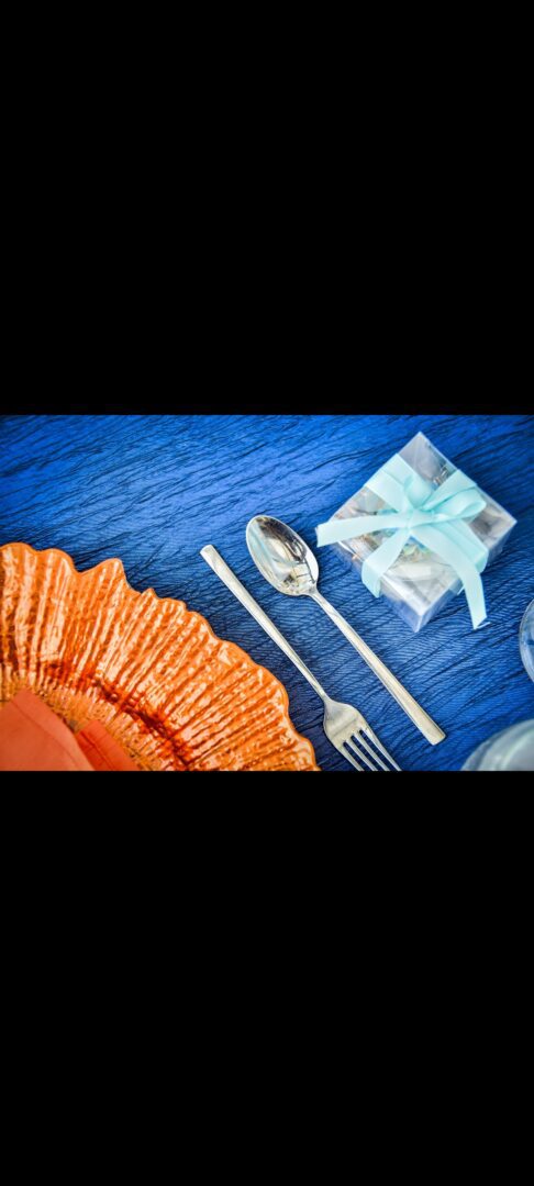A table with silverware and a gift box.