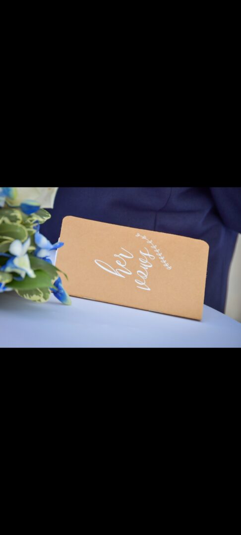 A card sitting on top of a table next to flowers.