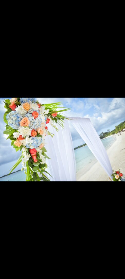 A wedding arch with flowers on the beach