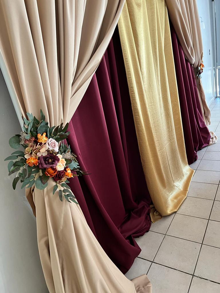 A red and gold curtain with flowers on the side