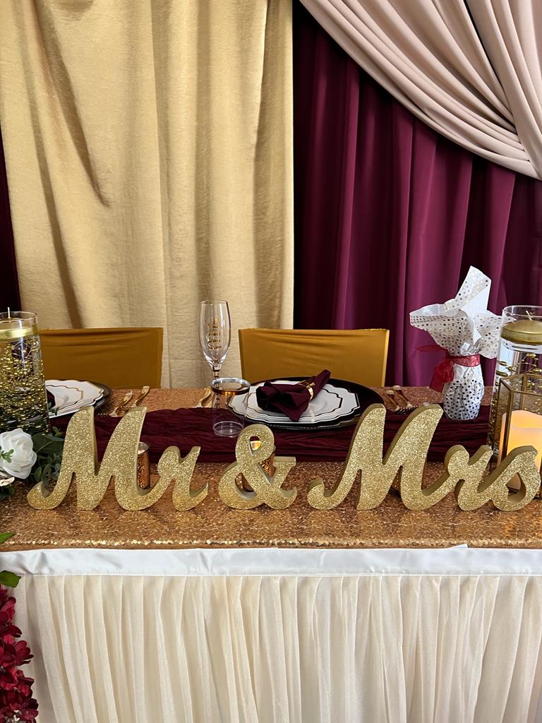 A table with a gold sign that says mr and mrs.