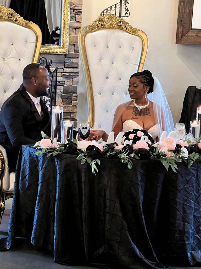 A couple sitting at the head table for their wedding.