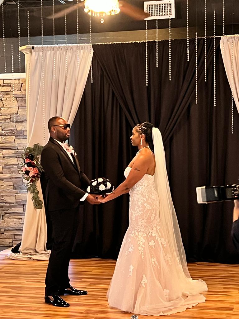 A bride and groom holding hands in front of the camera.