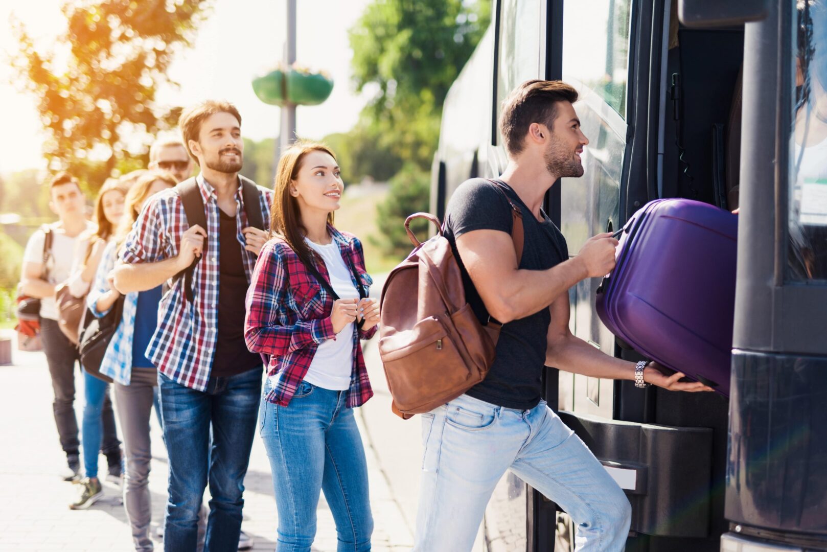 A group of people loading luggage onto a bus.