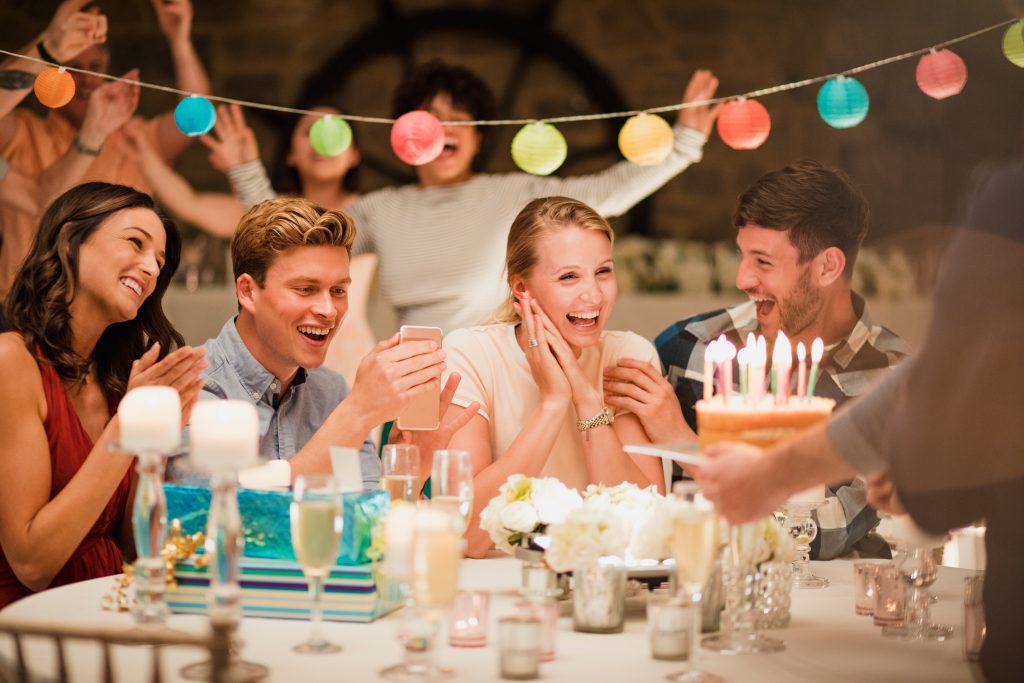 A group of people sitting at a table with cake.