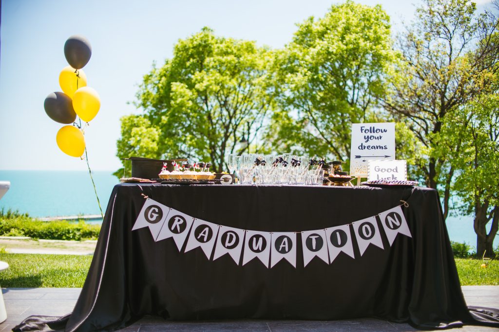 A table with graduation banners and balloons on it.