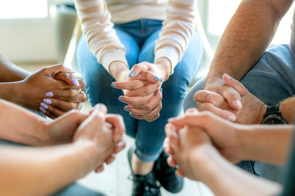 A group of people holding hands in a circle.