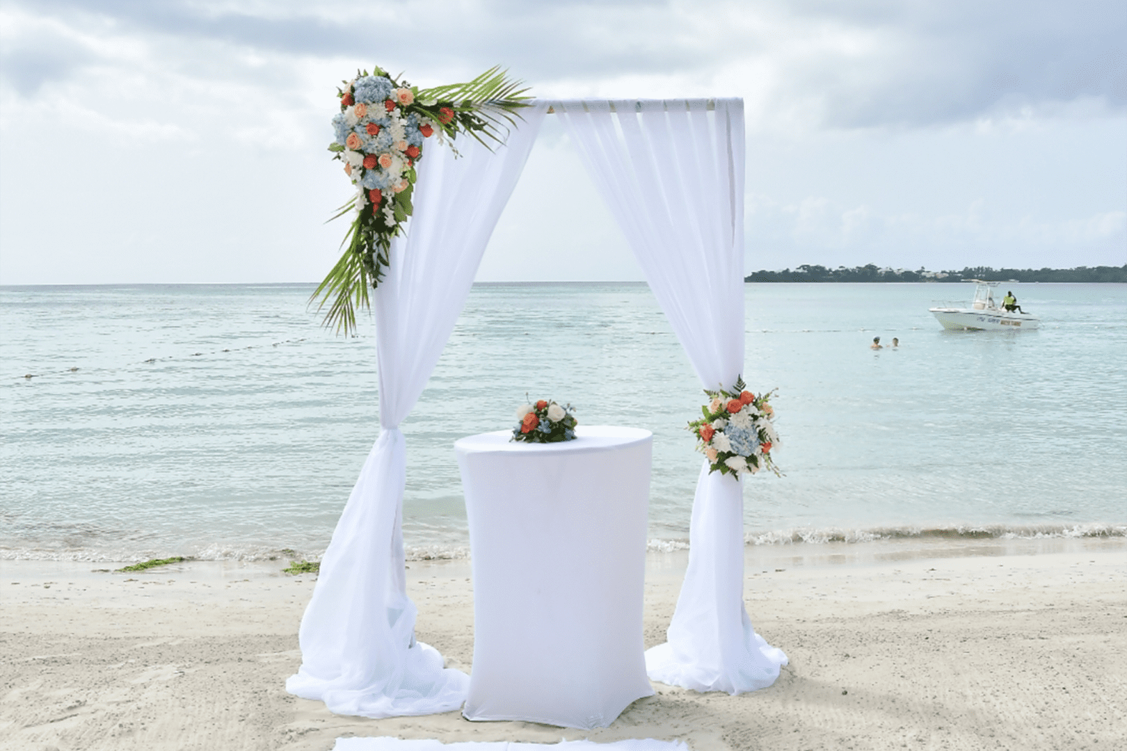 A wedding arch on the beach with flowers