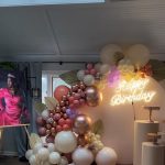 A room with balloons and a sign that says happy birthday