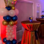 A table with a crown on it and balloons