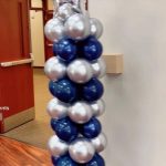 A tall column of balloons in blue and silver.